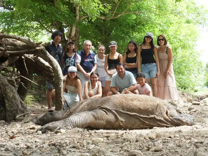 Keluarga besar Pak Ricky dari Jakarta berfoto bersama satwa Komodo di kawasan Taman Nasional Komodo Labuan Bajo.