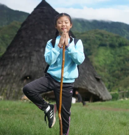Wisatawan berpose di depan rumah kerucut tradisional Mbaru Niang Desa Adat Wae Rebo Flores.